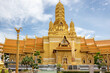 Golden designed buddhist temple architecture pagoda and standing buddha statue at the Ancient City Siam Bangkok historical museum site.