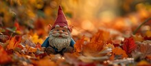 A Garden Gnome With A Long Beard Is Sitting Among A Pile Of Leaves. This Toy Lawn Ornament, Portraying A Fictional Character, Is A Sculpture That Adds Art To The Outdoor Event