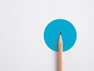 Wall Mural - Minimalist template of a wooden pencil on a blue circle on white background. Abstract minimal design.