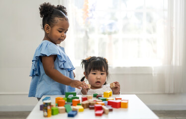 Wall Mural - Portrait happy little asian girl learn and study.student, development, leisure, school, kid, child.young girl play activity skill brain training play with toy build wooden blocks board education game