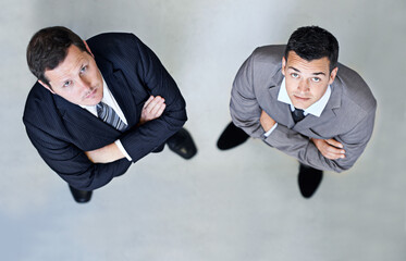 Businessman, portrait and professional team above in company or business on a gray studio background. Top view of man, employees or colleagues with arms crossed in confidence for corporate management