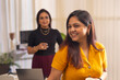 © IndiaPix - Two businesswomen discussing project on laptop at office workstation