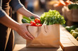 hands holds Paper bag filled with fresh vegetables, fruits and herbs vegetable market on background