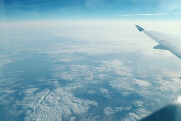 Wall Mural - airplane wing soaring above fluffy clouds, ideal for travel and aviation concepts