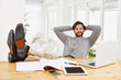 © YATrainer/peopleimages.com - Businessman, relax and smile with computer at house for remote, freelance work and internet research. Male person, hands and feet on desk for wellness and technology in home office for online job