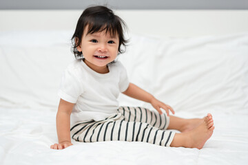 Wall Mural - happy toddler baby sitting on bed