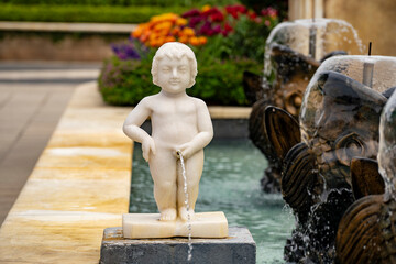 Wall Mural - Statue of a naked pissing boy in the form of a street fountain in a square in Da Nang, Vietnam, closeup