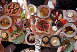 Fototapeta Kwiaty - Eating together. Table full of food, from above, wide view. Enjoying food, dining with family, friends.