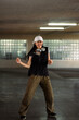 © Prathankarnpap - Cheerful young woman dancing in style of hip hop aesthetics in parking garage