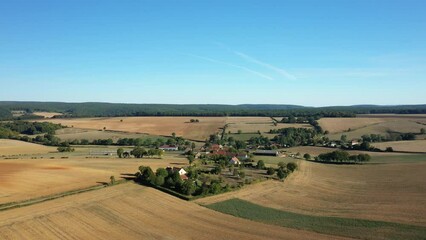 Wall Mural - A traditional village in the green countryside with fields after harvest in Europe, France, Burgundy, Nievre, in summer on a sunny day.