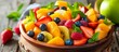 A colorful fruit salad made with a variety of natural foods like berries, citrus fruits, and hardy kiwi, served in a bowl on a rustic wooden table