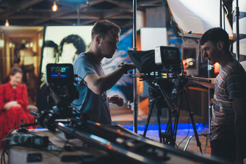 Wall Mural - Director of photography with a camera in his hands on the set. Professional videographer at work on filming a movie