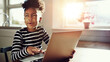 © Flamingo Images - laughing little black girl working on a laptop in a kitchen