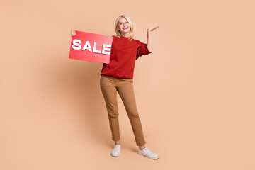 Sticker - Full length photo of excited funky woman wear red sweater rising sale billboard isolated beige color background