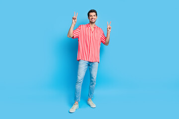 Wall Mural - Full body photo of pleasant nice guy wear stylish shirt jeans trousers two hands showing v-sign symbol isolated on blue color background