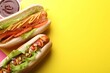 Leinwandbild Motiv Delicious hot dogs with lettuce and sauces on yellow background, flat lay. Space for text