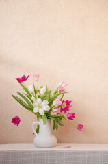 Wall Mural - tulips in vase on table on background wall