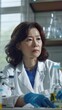 © DyrElena - middle aged Korean woman wearing lab coat doing experiments