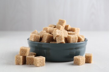 Wall Mural - Brown sugar cubes on light table, closeup