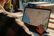 © Suwanlee - A logistics analyst working on a laptop and showing a map of routes.