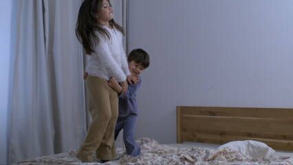 Wall Mural - Children Jumping on Bed in Super Slow Motion, Captured at 800 fps, siblings bonding together while bouncing captured with a high speed camera