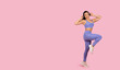 © Prostock-studio - Joyful woman dancing in sportswear with headphones on pink backdrop