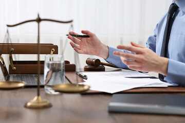 Wall Mural - Lawyer with pen working at wooden table, closeup