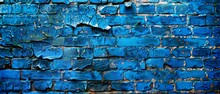 A once-vibrant blue paint peels away from this brick wall, revealing the relentless effects of weather and time on its crumbling surface.