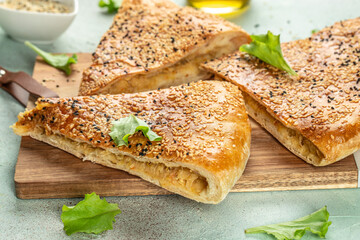 Canvas Print - pie with puff pastry, onions and potatoes on a wooden board. top view. copy space for text