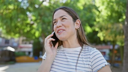 Sticker - Smiling woman talking on phone in sunny park