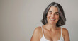 © Elena - Studio portrait of happy and attractive mature woman with gray hair, smiling and wearing white tank top