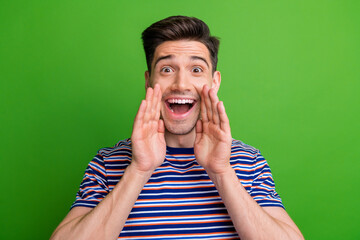 Wall Mural - Portrait of overjoyed ecstatic man with bristle wear stylish t-shirt hands on mouth announcing big sale isolated on green color background