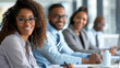 © Studio Nova - close-up of a professional woman with glasses, likely part of a diverse business team in a meeting.