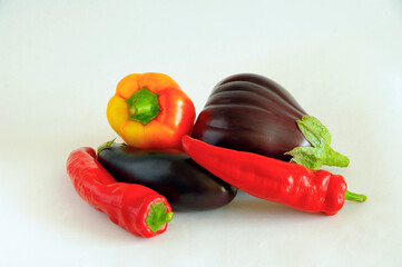 Red pepper and eggplant on a white background. Close-up. Selective focus with copy space.