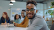 © MP Studio - group of young professionals or students in a collaborative setting, with a focus on a young man in glasses smiling at the camera.