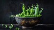 Fresh peas and a bunch of ripe green pods in a porcelain planter with a black backdrop