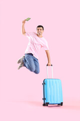 Sticker - Jumping male tourist with suitcase and passport on pink background