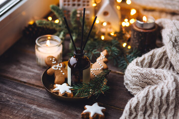 Wall Mural - Creating cozy holiday Christmas home atmosphere. Liquid reed diffuser with sticks with xmas scent: vanilla, gingerbread cookies, pine, sweet pie, cinnamon, anise. Aromatherapy, wellness, relaxation