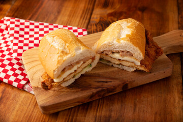 Wall Mural - Mexican Torta de Milanesa. Sandwich made with bolillo bread, telera or baguette, split in half and filled with various ingredients, in this case breaded chicken meat with Oaxaca cheese.