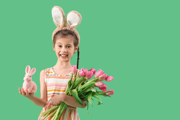 Poster - Cute little girl wearing bunny ears with Easter rabbit and tulips on green background