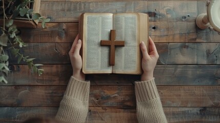 beautiful young woman reading the bible holding an old wooden cross