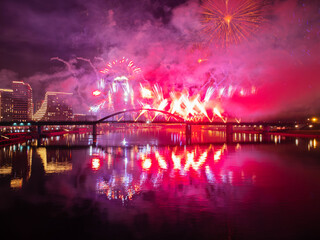 Wall Mural - Drone flight above colorful fireworks on the black sky background over-water