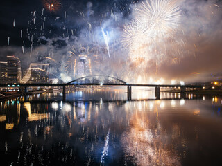 Wall Mural - Drone flight above colorful fireworks on the black sky background over-water