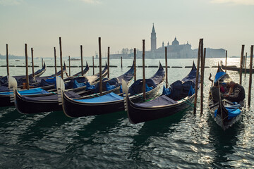 Gondolas docked at San Marco Canal with San Giorgio Maggiore island in the background in Venice, Italy	
