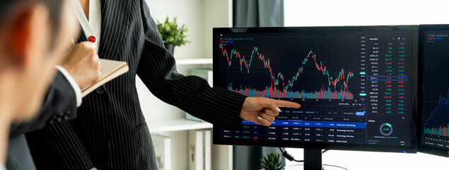 Wall Mural - Group of profession trader discuss about stock market investment while point the increasing financial graph displayed on computer. Stock market investment concept Cropped image. Burgeoning.