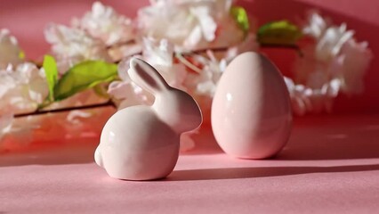 Wall Mural - Porcelain Easter hare and egg with an apple tree branch on a pink background.