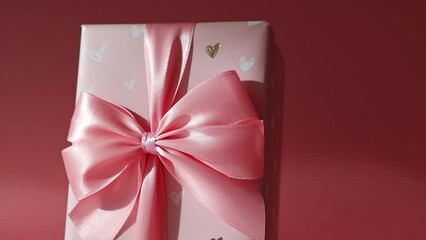 Wall Mural - One gift box with a bow on a pink background.