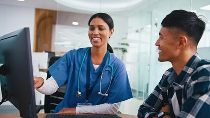 Wall Mural - Female doctor or nurse meeting with male patient for appointment in hospital looking at computer monitor - shot in slow motion