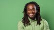 Portrait elegant sexy smiling African man with dark and perfect skin and long hair,on light green background. Advertising of cosmetic products, spa treatments, shampoos and hair care products