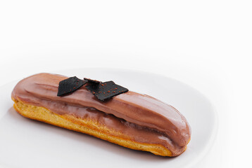 Wall Mural - Eclair topped with chocolate on white plate